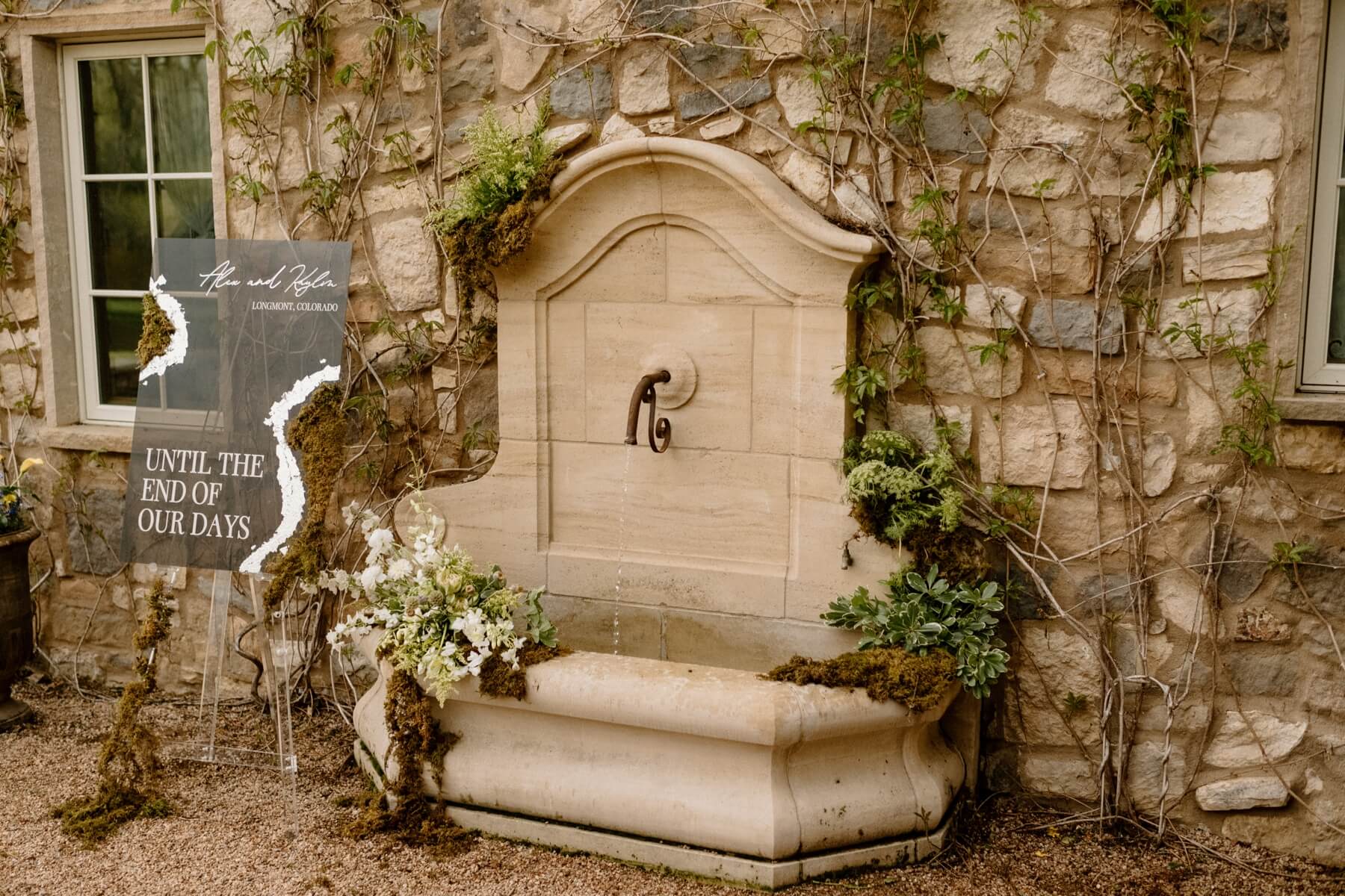 Stone fountain with modern wedding welcome sign that says until the end of our days