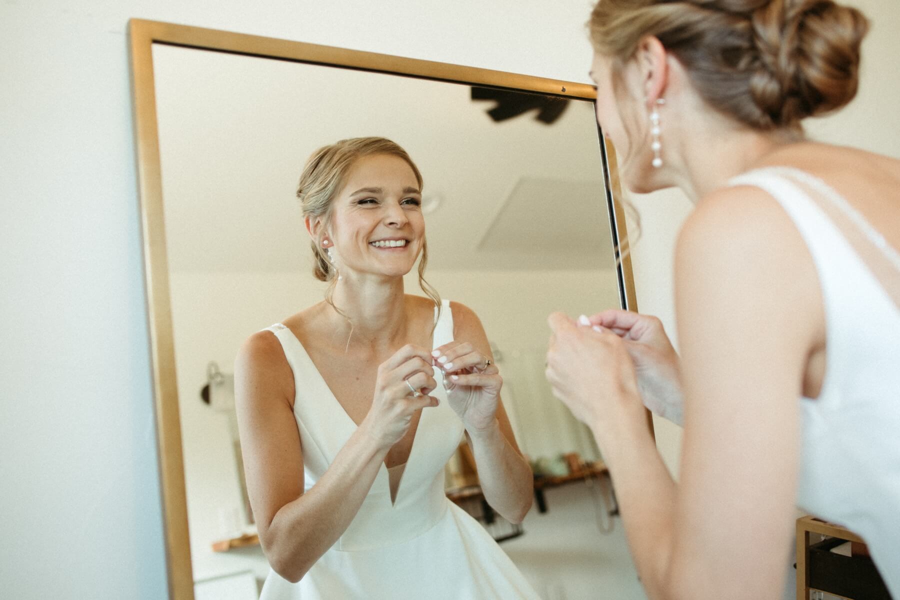 Bride looking in mirror while getting ready at North Star Gatherings