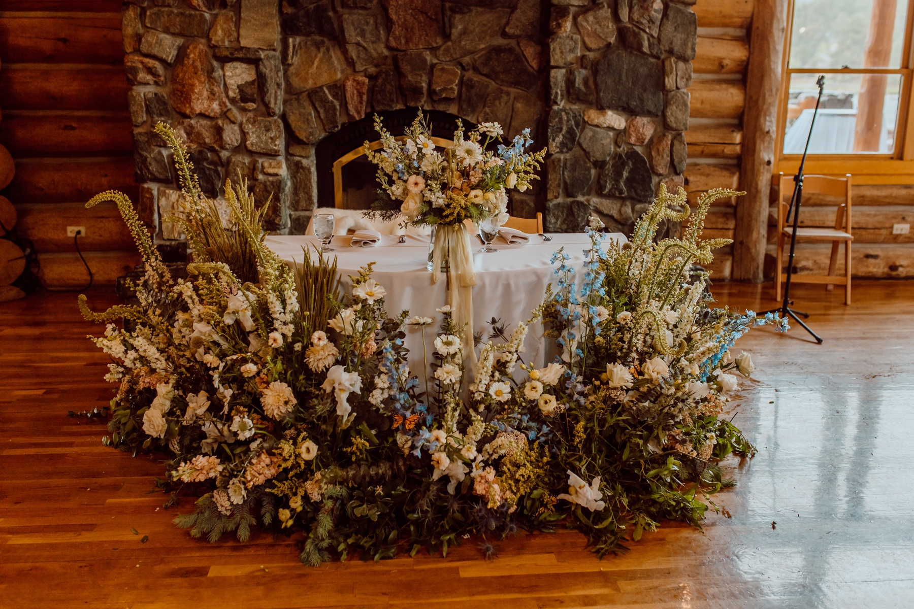Wildflower arrangements in front of sweetheart table at Evergreen Lake House