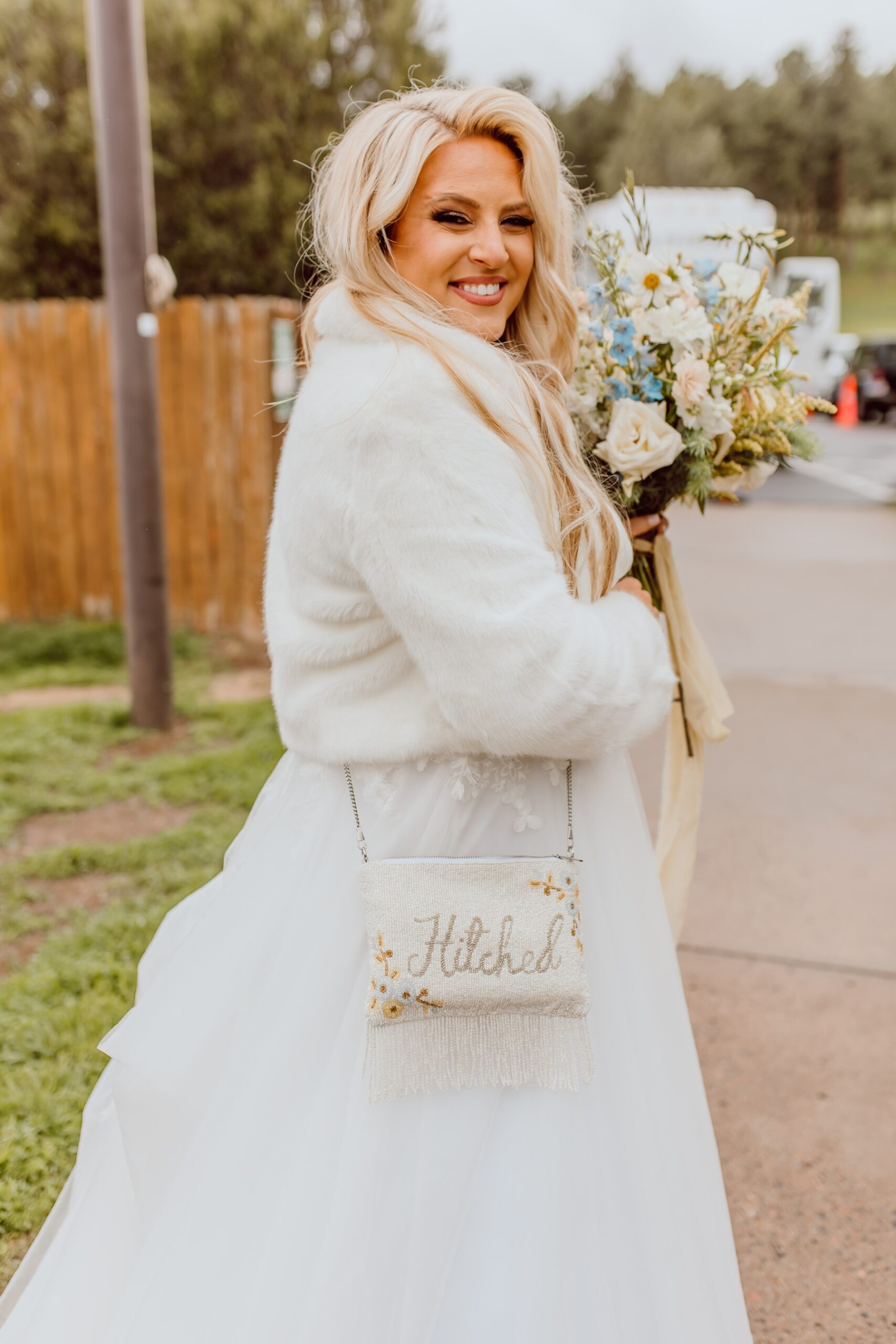 Bride wearing fur jacket with hitched crossbody purse