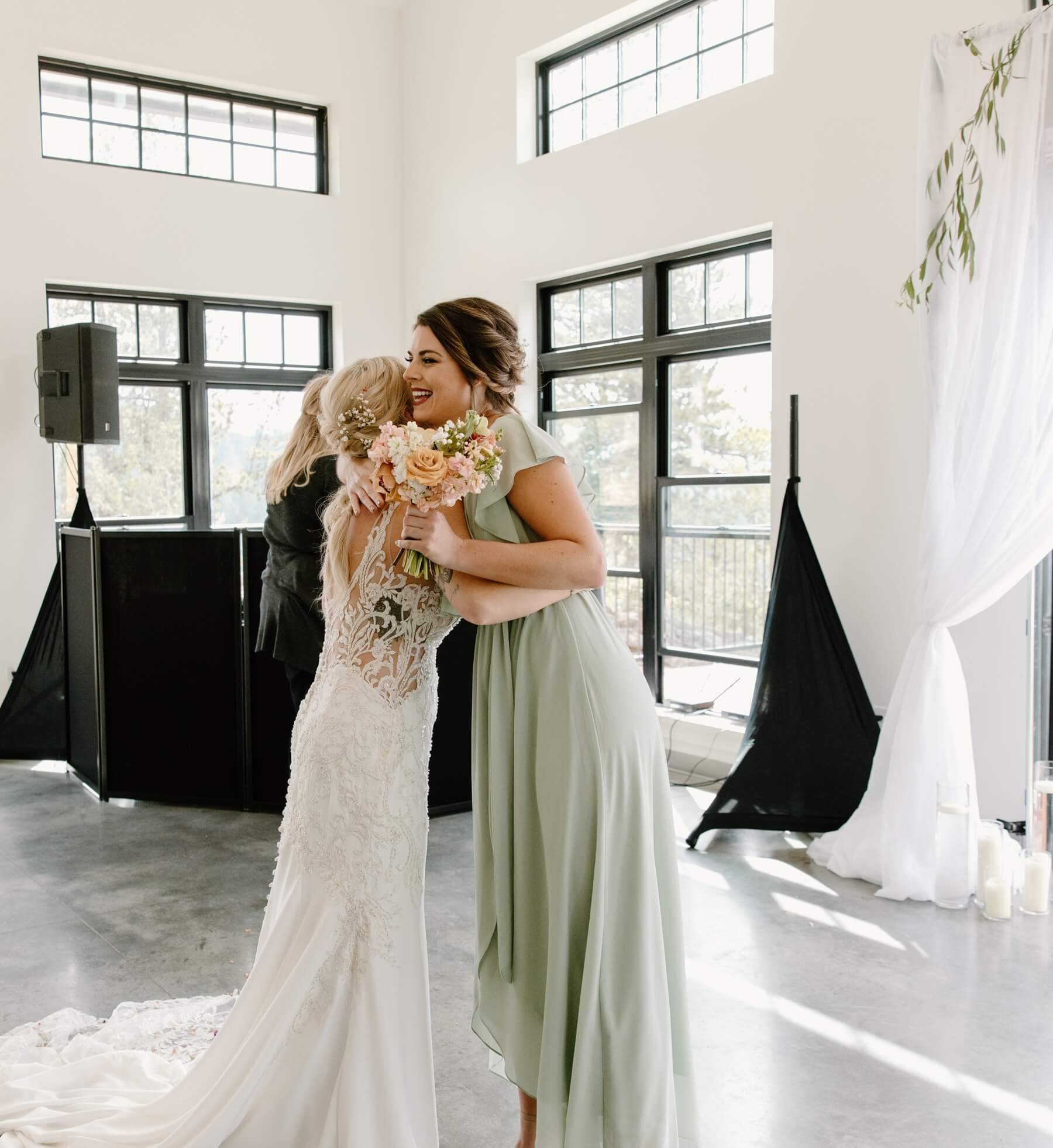 Bride and maid of honor hugging during reception