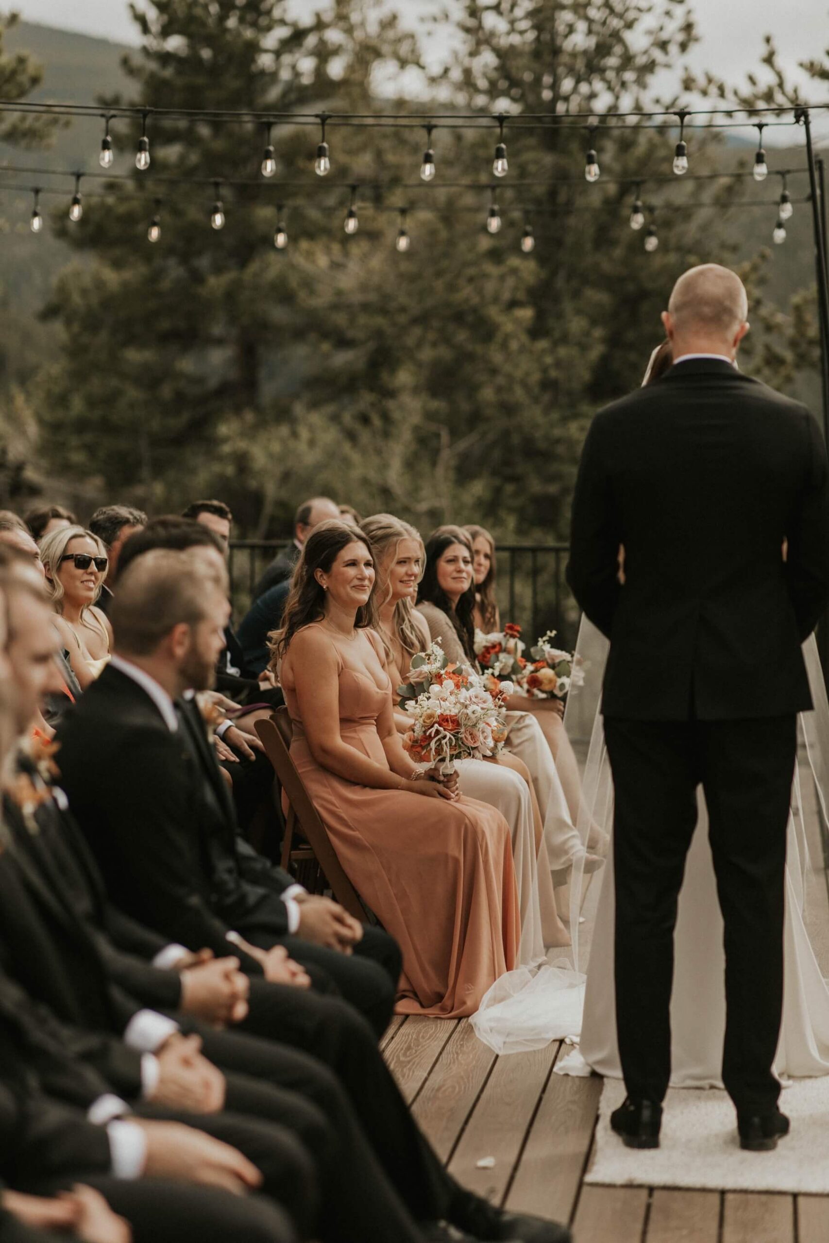 Bridesmaids sitting in front row and watching couple exchange vows