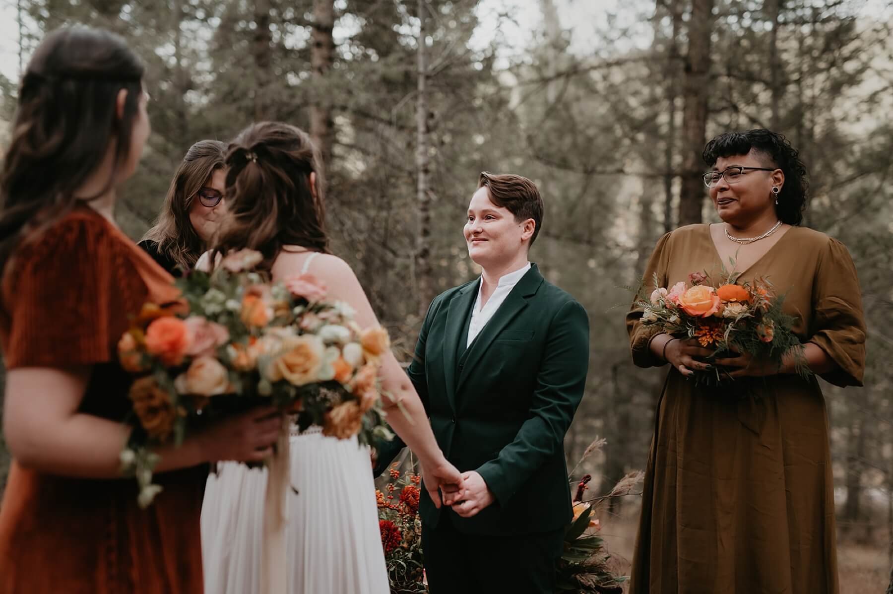 Couple holding hands and exchanging vows as maid of honor looks on